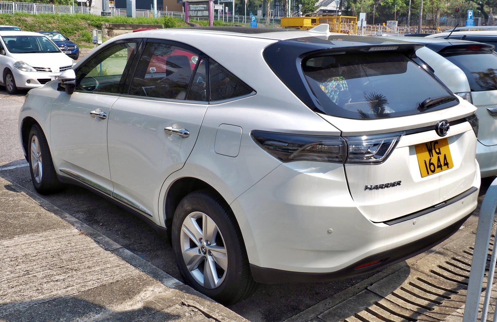 White Toyota Harrier SUV parked in a parking lot, rear three-quarter view with license plate WG 1644.