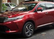 Front three-quarter view of a shiny red SUV parked along a curb, license plate SFA 776Z visible