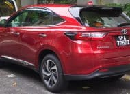 Red Toyota Harrier parked on a street, showing the rear three-quarter view and license plate SFA 7767Z.