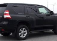 Rear-right three-quarter view of a black Toyota Land Cruiser Prado SUV parked on a paved surface.