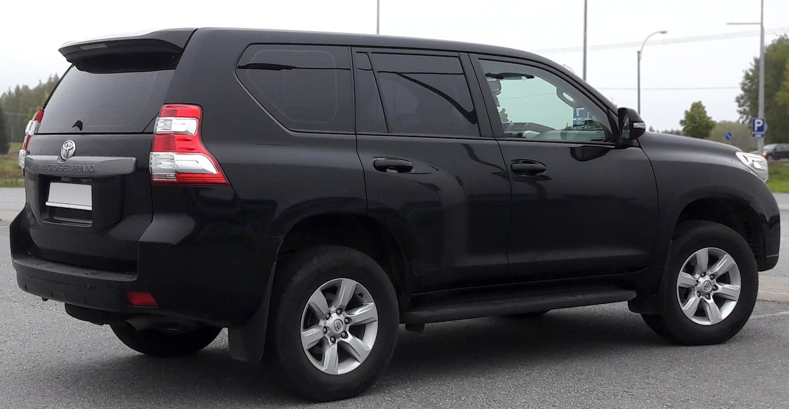Rear-right three-quarter view of a black Toyota Land Cruiser Prado SUV parked on a paved surface.