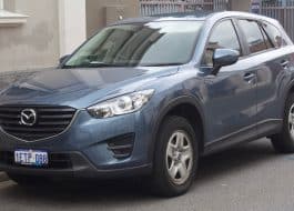 Blue Mazda SUV parked on a street, front-left angle, with license plate visible (Australia).