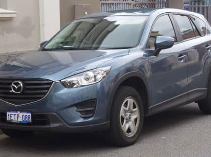 Blue Mazda SUV parked on a street, front-left angle, with license plate visible (Australia).